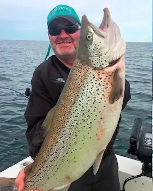 Angler showing off a large Lake Ontario brown trout.