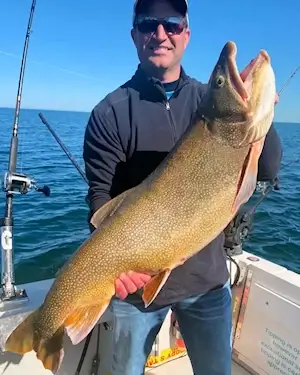 Angler showing off a large Lake Ontario lake trout.