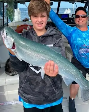 Angler showing off a large Lake Ontario steelhead.