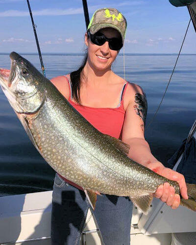 Pretty yopung lady displays giant king salmon caught in her charter trip.